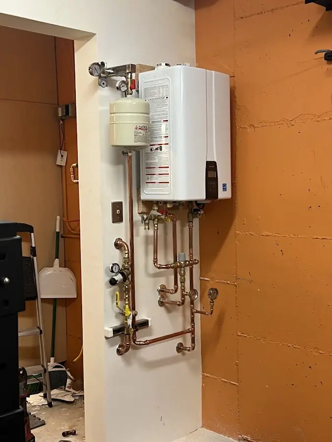 Plumbing technician inspecting water heater connections in McGregor